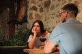 Young woman getting bored during date with man at cafe