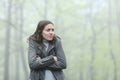 Woman getting cold complaining in a foggy park