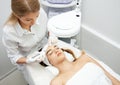 Woman getting facial beauty treatment in medical spa center. Skin care and rejuvenation concept. Beautician cleaning and touching Royalty Free Stock Photo