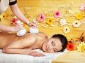 Woman getting herbal ball massage.