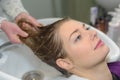 Woman getting long hair washed in hairdressing salon