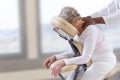Senior woman getting massage in chair in therapy room Royalty Free Stock Photo