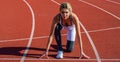 Woman getting ready to start on stadium. Women sprinters at starting position ready for race on racetrack. Girl getting Royalty Free Stock Photo