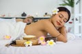 Woman getting spa hot stones massage. Lying on a massage table, relaxing with eyes closed. Spa Thai therapy treatment Royalty Free Stock Photo