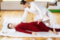 Woman getting traditional thai stretching massage by therapist. Royalty Free Stock Photo