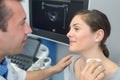 Woman getting ultrasound thyroid from doctor