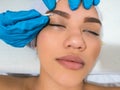 Woman getting a wax on her eyebrow, up close. Woman in a beauty parlor. Plastic surgery clinic