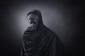 Woman ghost in hooded cloak over dark background Royalty Free Stock Photo