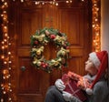 Woman with gifts at the front door. Magic on Christmas night