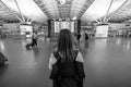 Woman, girl with backpack looks at the board with the schedule of flights and arrival at International Airport. Evening, night.