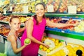 Woman with girl buying apples Royalty Free Stock Photo