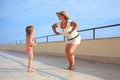 Woman and girl do morning exercise on veranda