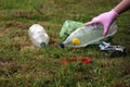 Woman girl in glove Saving the planet Earth nature and environment from pollution of plastic. taking bottle from the grand green Royalty Free Stock Photo