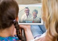 Woman and girl having a video call with senior couple on digital tablet Royalty Free Stock Photo