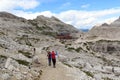 Woman and girl hiking towards alpine Hut Bullelejochhutte in Sexten Dolomites, South Tyrol