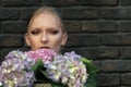 Woman or girl with hortensia flowers on brick wall Royalty Free Stock Photo