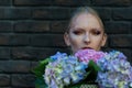 Woman or girl with hortensia flowers on brick wall Royalty Free Stock Photo