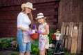 Woman and girl, mother and daughter, gardening together planting flowers in the garden. Looking at camera Royalty Free Stock Photo