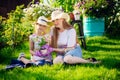 Woman and girl, mother and daughter, gardening together planting flowers in the garden. Looking at camera Royalty Free Stock Photo
