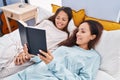 Woman and girl mother and daughter reading book at bedroom Royalty Free Stock Photo