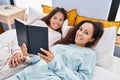 Woman and girl mother and daughter reading book at bedroom Royalty Free Stock Photo