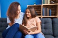 Woman and girl mother and daughter reading book at home Royalty Free Stock Photo