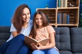 Woman and girl mother and daughter reading book at home Royalty Free Stock Photo