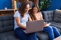 Woman and girl mother and daughter using laptop write on notebook at home Royalty Free Stock Photo