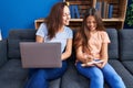 Woman and girl mother and daughter using laptop write on notebook at home Royalty Free Stock Photo