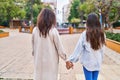 Woman and girl mother and daughter walking with hands together at park Royalty Free Stock Photo