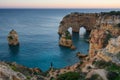 Woman girl in Natural arch cliffs of Praia da Marinha beach at sunset beautiful landscape with atlantic ocean, in Lagoa Portugal