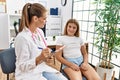 Woman and girl pediatrician and patient having medical consultation at clinic Royalty Free Stock Photo