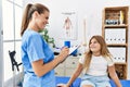 Woman and girl physiotherapist and patient having rehab session at physiotherapy clinic