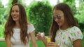 Woman and girl playing with soap bubbles in park. Family laughing outdoors Royalty Free Stock Photo