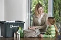 Woman And Girl Preparing Waste Paper For Recycling