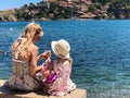 Woman and girl sitting on a stone wall by the harbor in Collioure, France Royalty Free Stock Photo