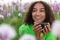 Woman Girl Teenager Field of Flowers Drinking Cup of Coffee or Tea Royalty Free Stock Photo