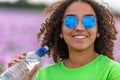 Woman Girl Teenager Field of Flowers Wearing Sunglasses Drinking Water Bottle Royalty Free Stock Photo