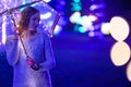 Woman or girl with umbrella with lights during the rain, lights and garlands. Rain atmosphere, art photo. Horizontal photo. With Royalty Free Stock Photo