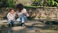 Woman girl watching reptile in sunny park. African family enjoying wildlife. Royalty Free Stock Photo