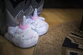 Woman or a girl wearing a cute plush fluffy slippers made in the form of unicorn