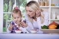 Woman and girl with yogurt bowl Royalty Free Stock Photo