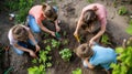 A woman and girls are planting plants in a garden AIG41 Royalty Free Stock Photo