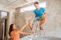 woman gives a bottle of water to a handyman repairing the ceiling