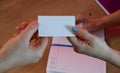 A woman gives a business card to a client. Notepad and tablet in the background on a wooden office table Royalty Free Stock Photo