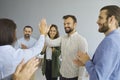 Woman gives five to her happy successful male colleague to applause of other business people. Royalty Free Stock Photo