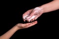 A woman gives her child a soap to protect against Coronavirus