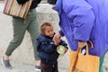 woman gives money to cute beggar girl downtown of Skopje,capital of Macedonia