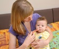 The woman gives to the sick baby medicine by means of the batcher Royalty Free Stock Photo