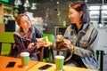 Woman gives to a stranger person or her friend euro banknote money in the interior of a cafe. The concept of lending money or Royalty Free Stock Photo